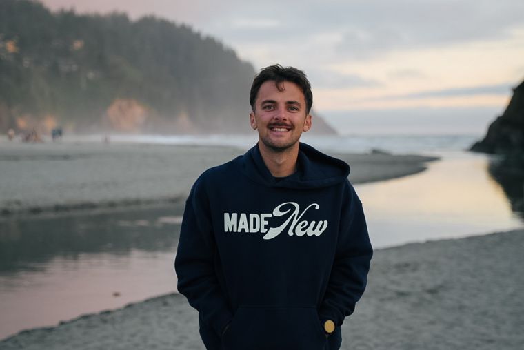 Trace Keller smiling on the Oregon coast in a Made New hoodie