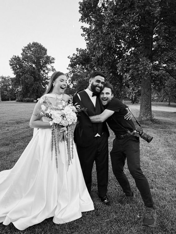 Trace Keller laughing with a bride and groom, camera on his strap