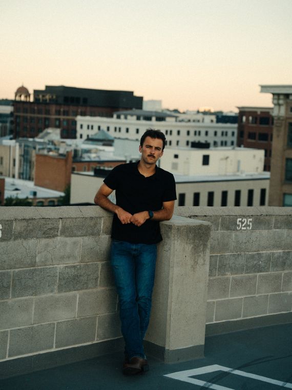 Trace Keller leaning on a Boise rooftop wall