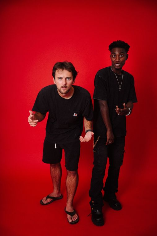 Trace Keller and a friend in front of a red backdrop