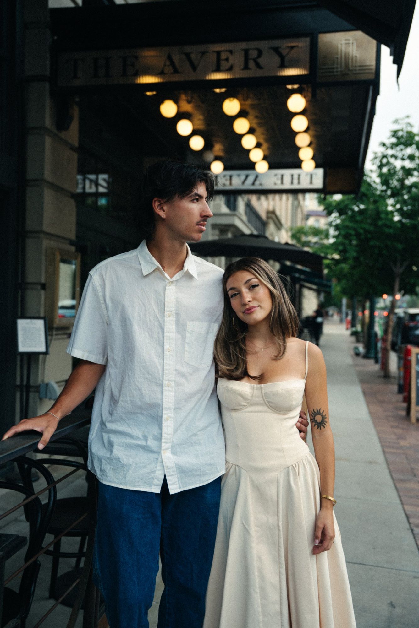 Lucas and Audry leaning together on a downtown Boise sidewalk under a lit awning