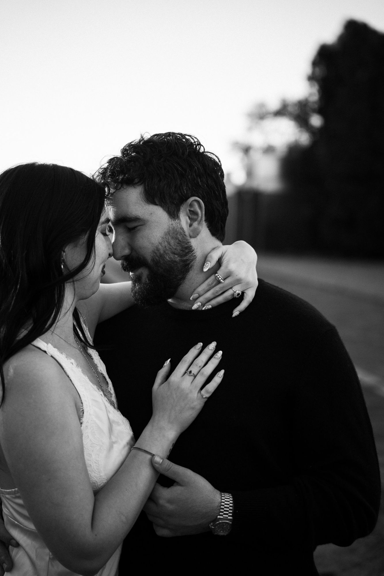 Black and white photo of James and Cora nose to nose with her hand resting on his chest