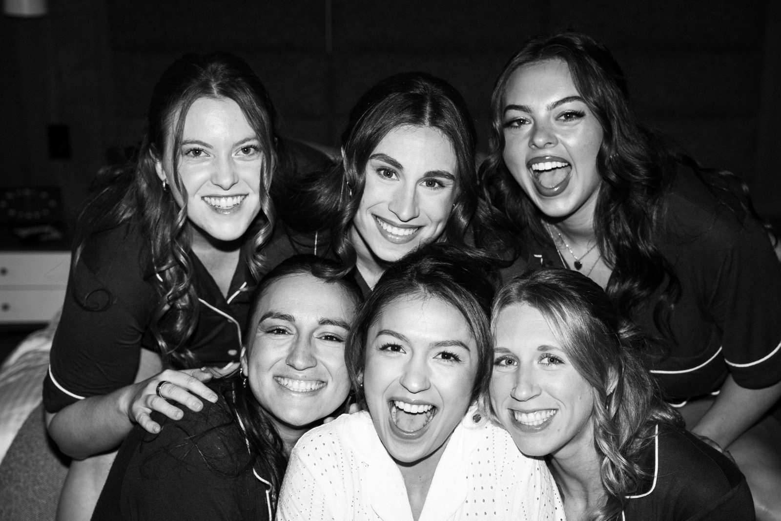 Black and white close-up of Becca and her five bridesmaids squeezed together, all laughing